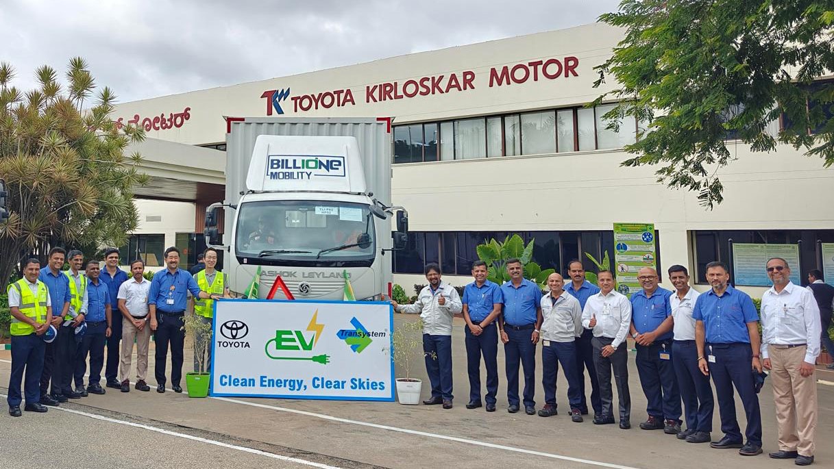 Toyota Kirloskar Motors employees with an EV outside the office as part of the 'going green' initiative.