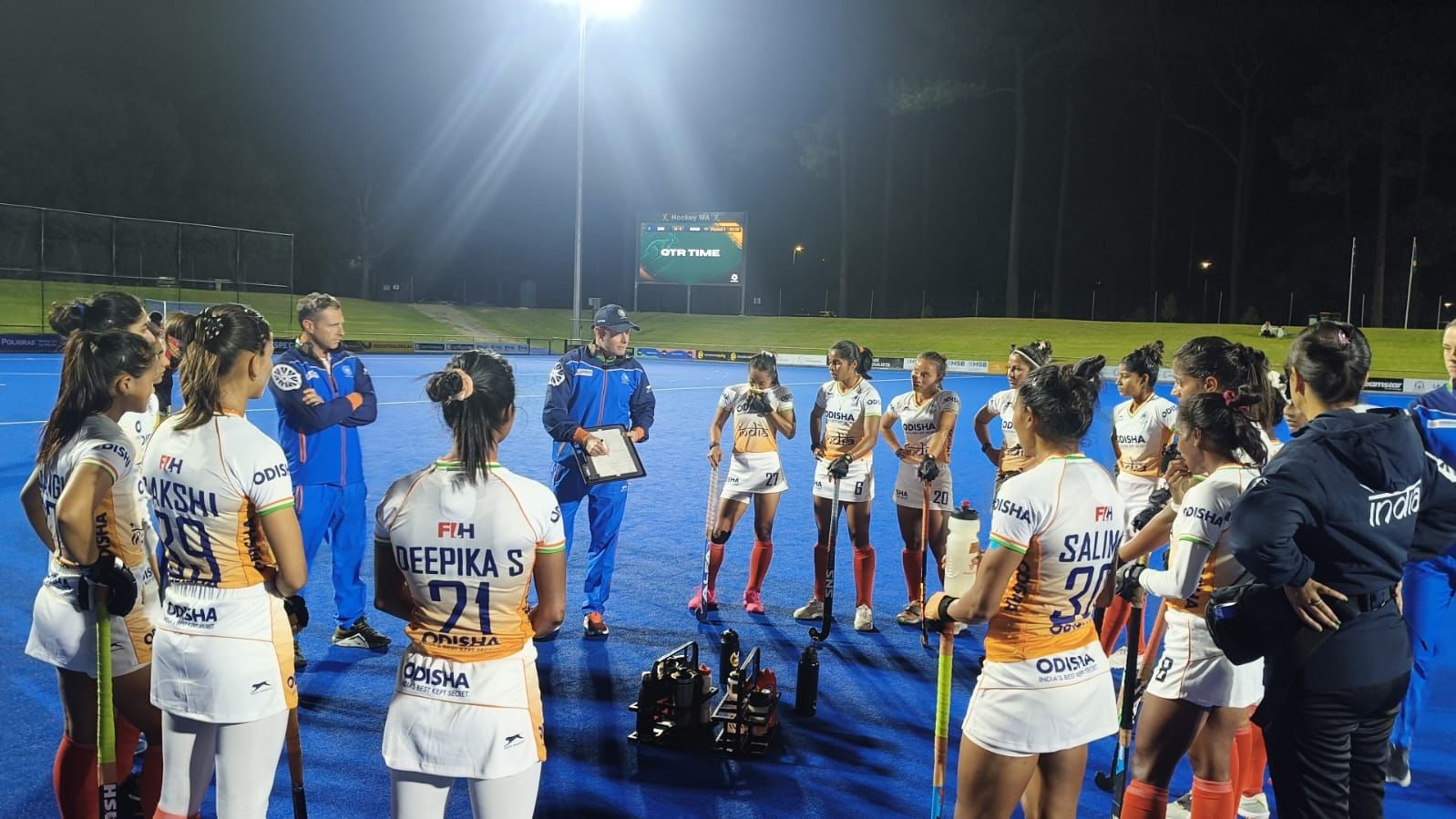 Indian women's hockey team in discussion with the coach.